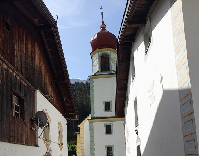 Kirchturm mit achteckigem Aufsatz und Zwiebelhaube zwischen den Häusern